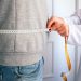 a woman measuring her waist with a measuring tape
